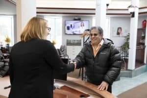 woman in dental implant clinic reception handshake with patient